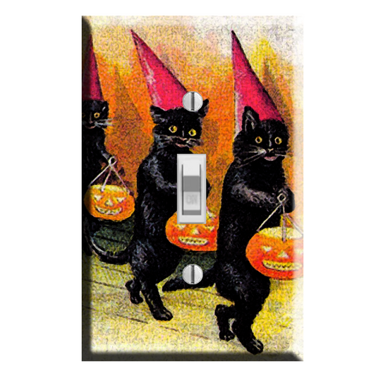 A rectangular light switch plate cover featuring a vintage-style Halloween illustration of three black cats wearing red pointed hats and holding orange jack-o'-lantern buckets, shown against a plain white background.