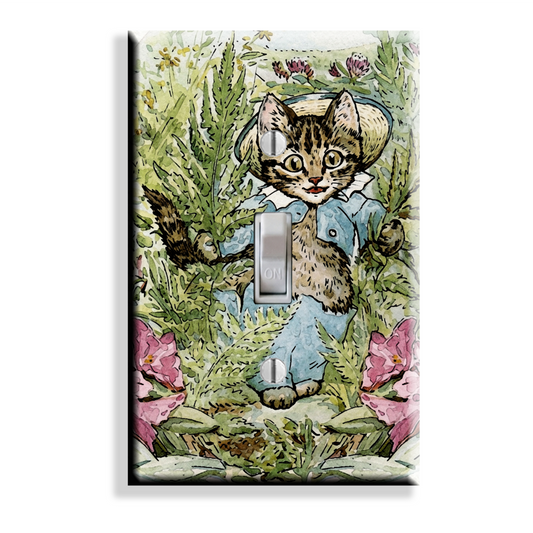 A rectangular light switch plate cover featuring a vintage-style illustration of a tom kitten in a blue outfit among green foliage and pink flowers, with a silver switch cutout in the center.