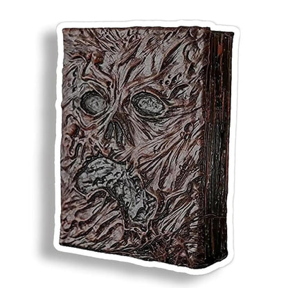 A die-cut vinyl sticker depicting Evil Dead's book with a textured, decaying face, shown on a white background with a drop shadow.