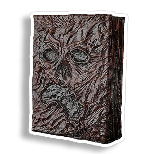 A die-cut vinyl sticker depicting Evil Dead's book with a textured, decaying face, shown on a white background with a drop shadow.